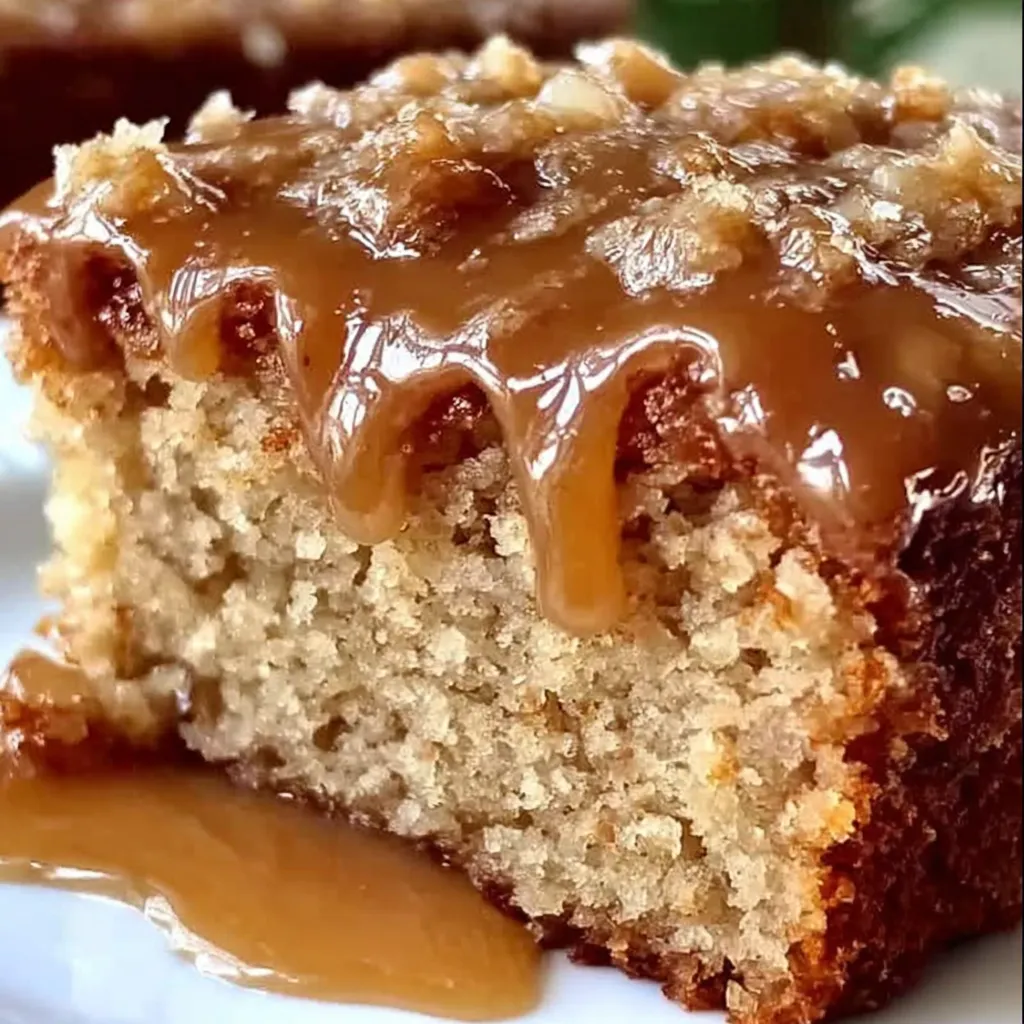 A slice of cake with caramel sauce drizzled on top.