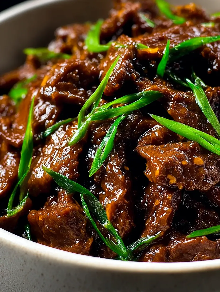 A bowl of beef with green onions.