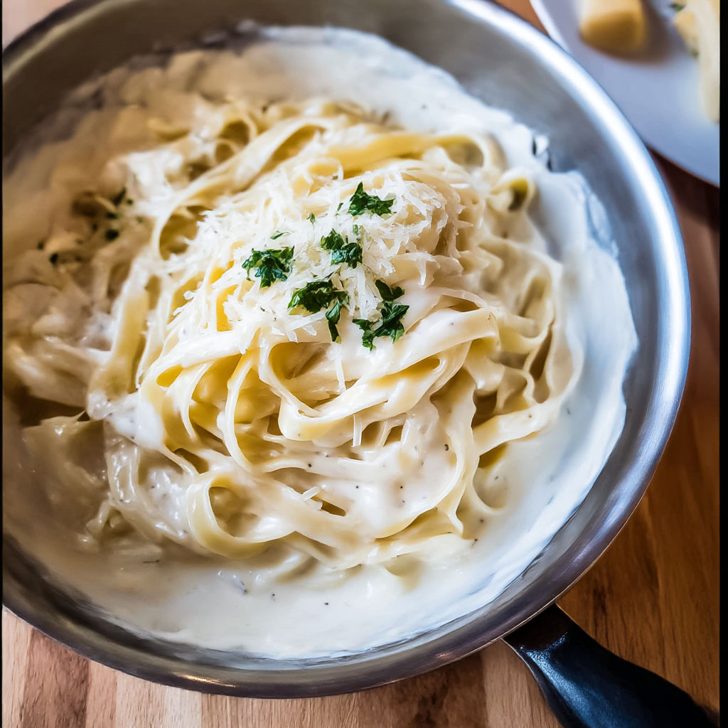 A bowl of pasta with cheese and herbs.