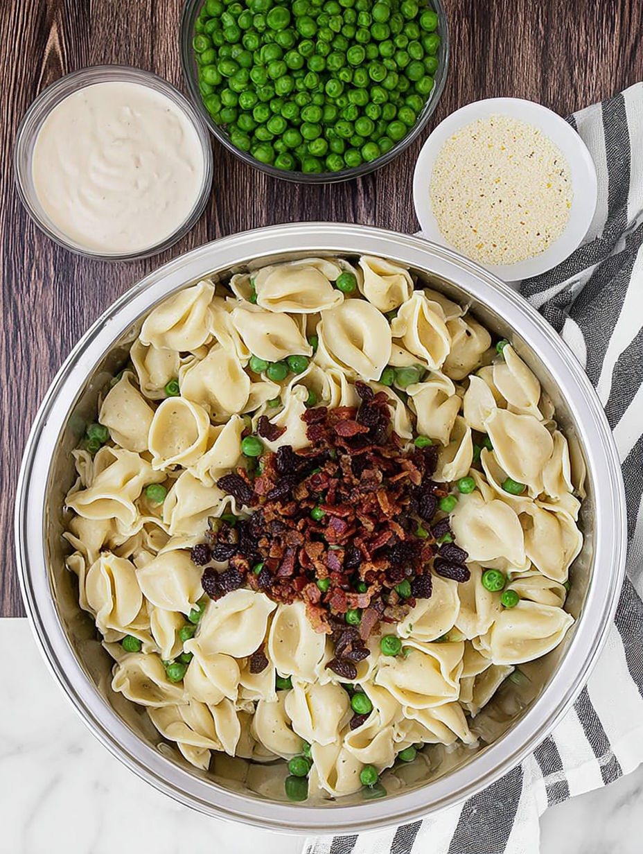 A bowl of pasta with peas and bacon.