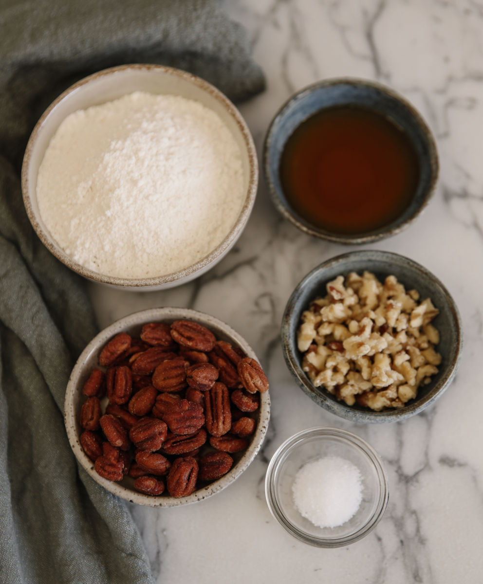 A bowl of nuts and a bowl of flour.