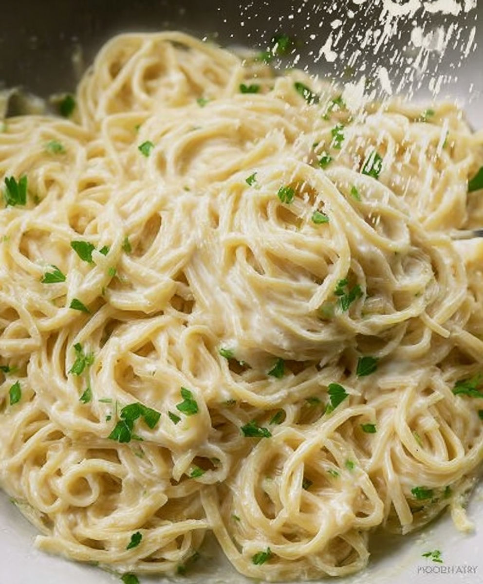 A bowl of pasta with green herbs on top.
