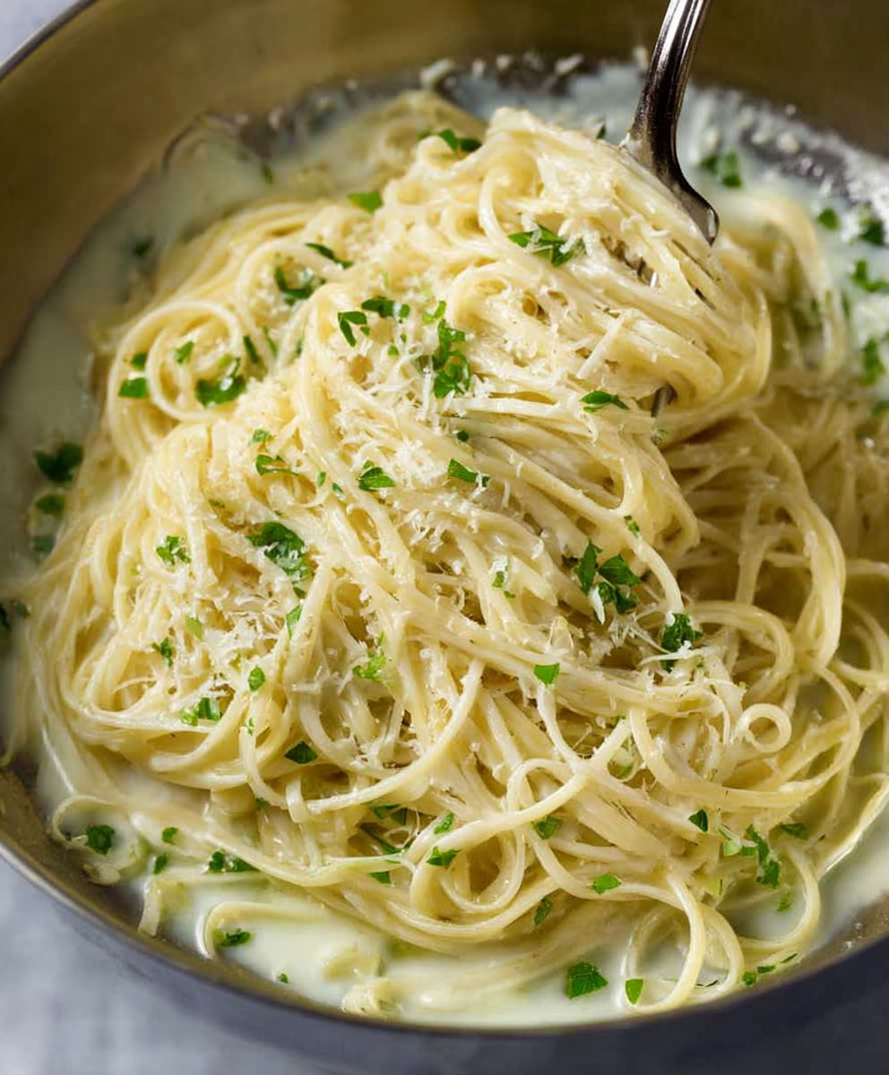 A bowl of pasta with cheese and herbs.