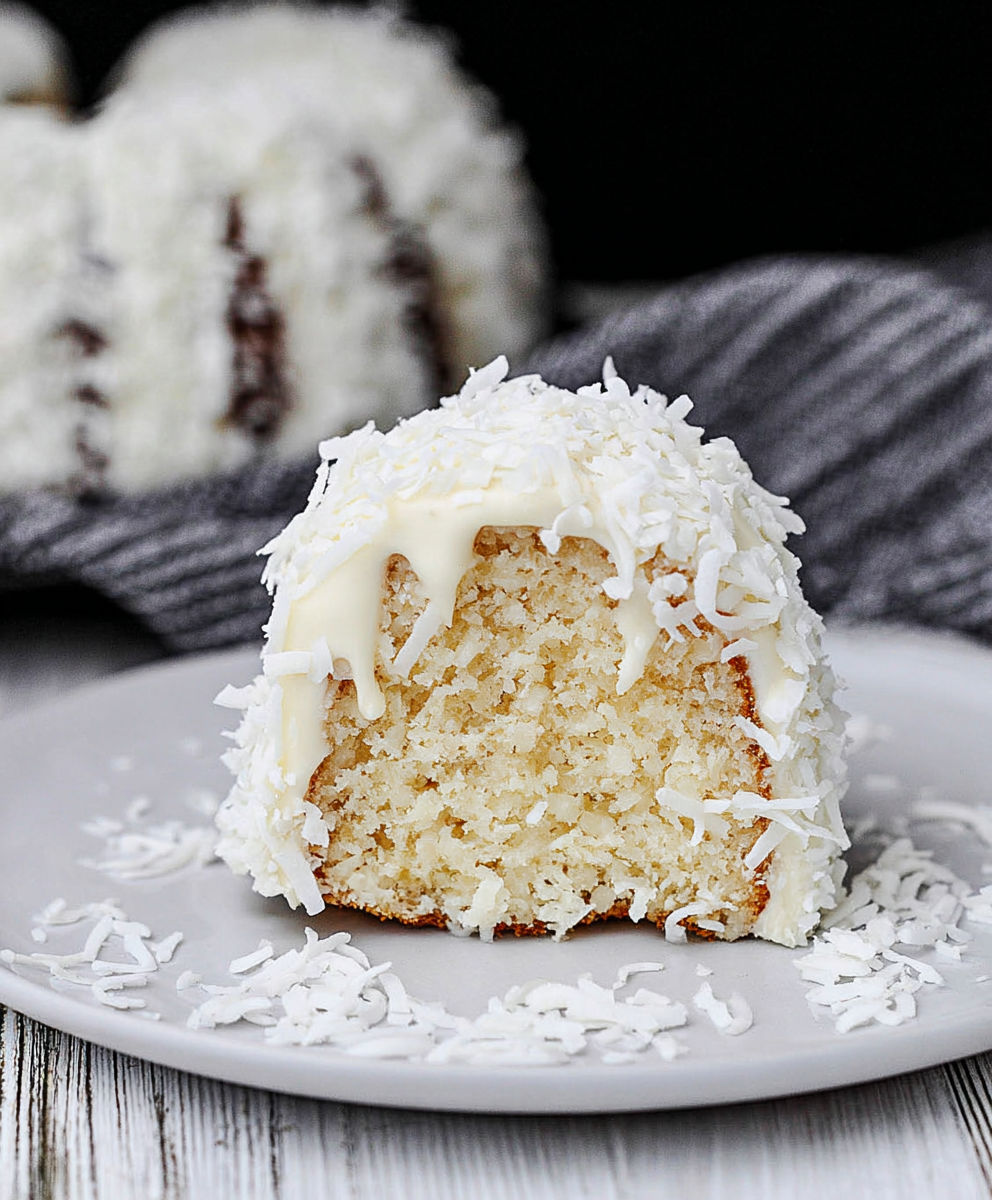 A white cake with white frosting and coconut on top.