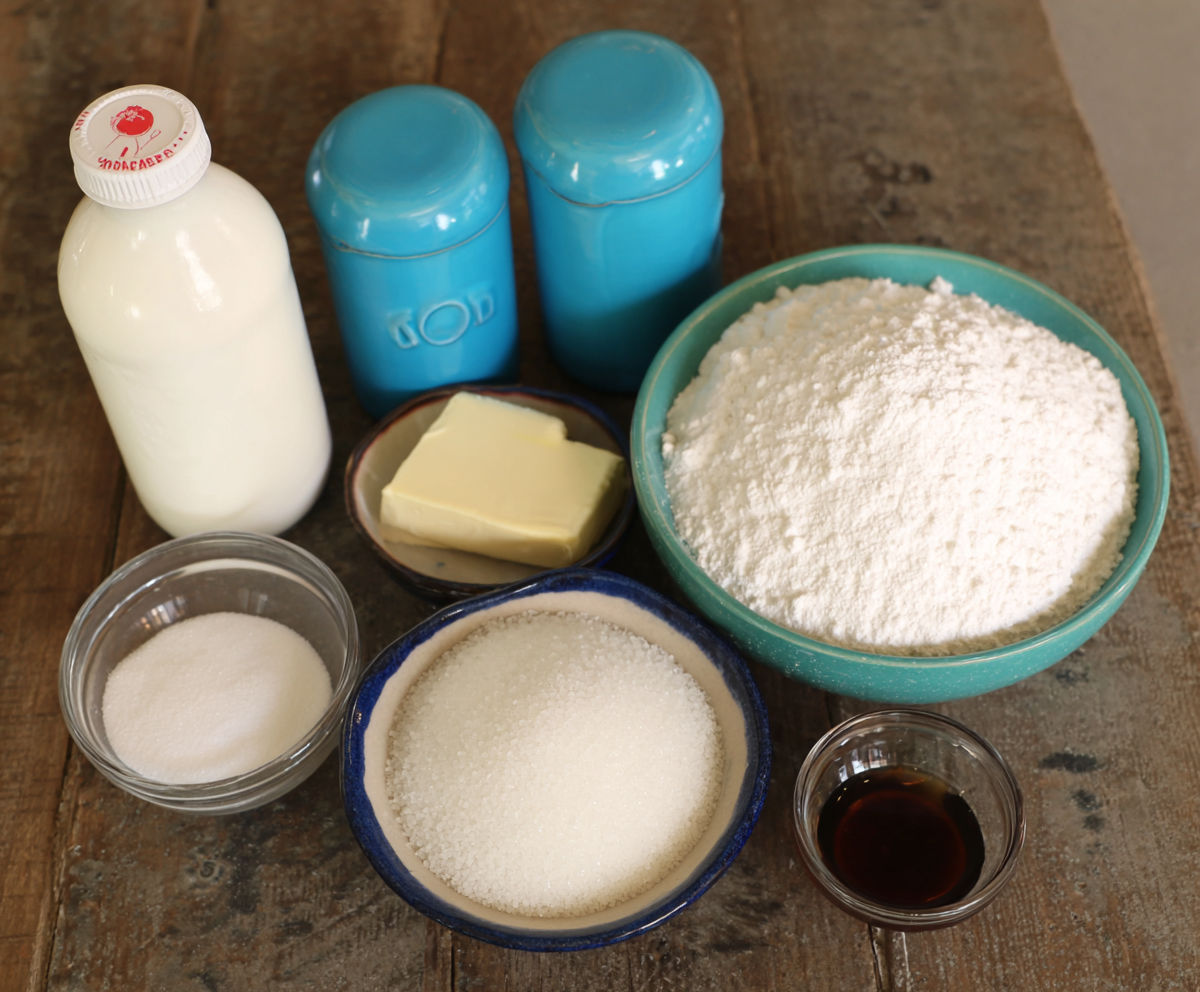 A bowl of flour and a bottle of milk.