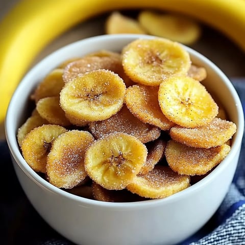 A bowl of banana slices with sugar on top.
