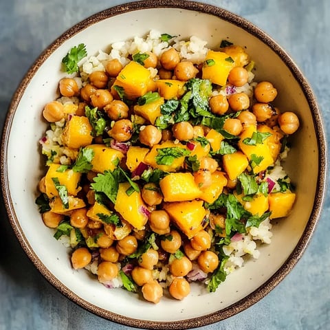 A bowl of rice and beans with a green garnish.