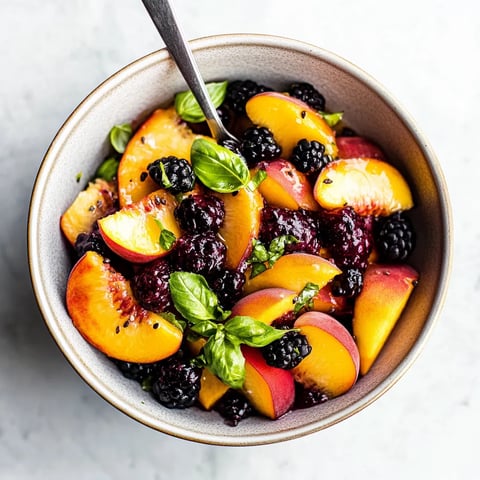 A bowl of fruit with a spoon in it.