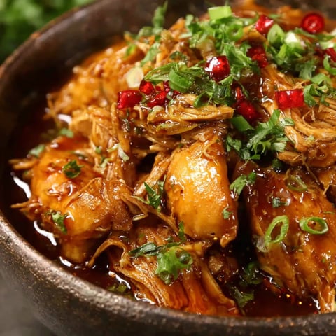 A bowl of food with red peppers.