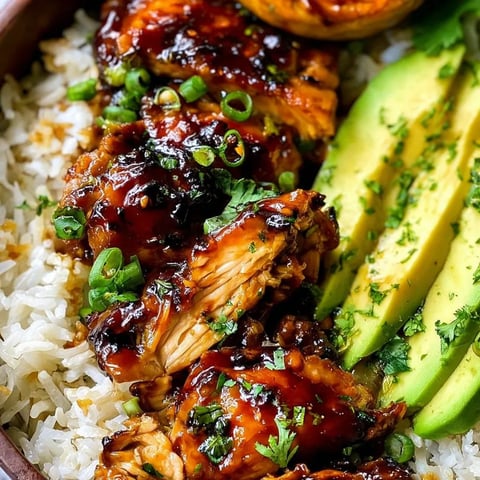 A plate of food with rice, meat, and avocado.