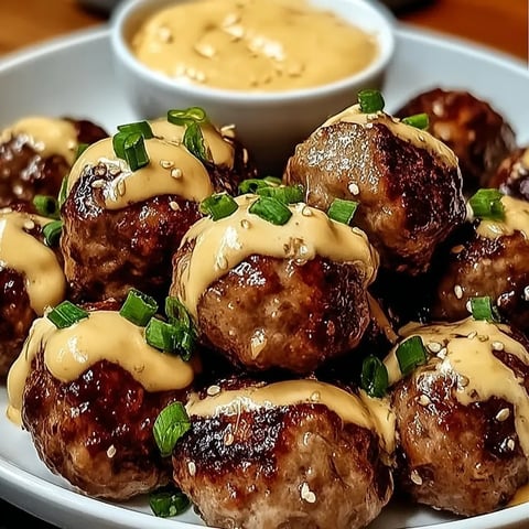 A plate of meatballs with sauce.