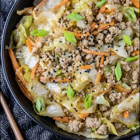 A bowl of food with carrots and meat.