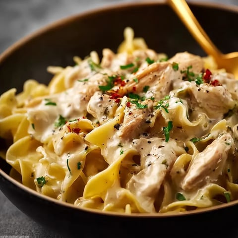 A bowl of pasta with chicken and cheese.