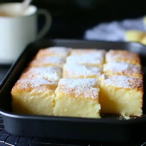 A pan of cake with powdered sugar on top.