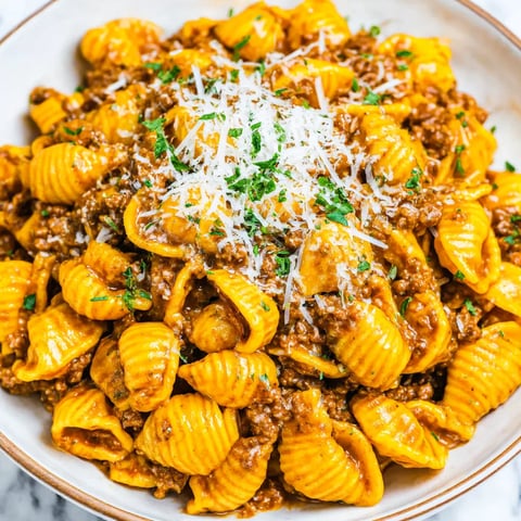 A bowl of pasta with meat and cheese.