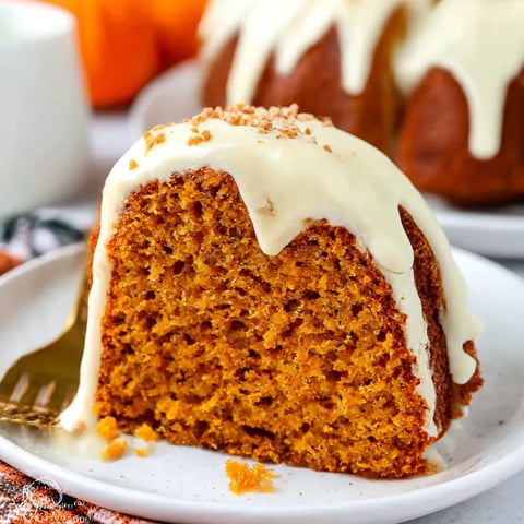 A slice of cake with white icing and orange decoration.