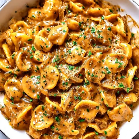 A bowl of pasta with cheese and sauce.