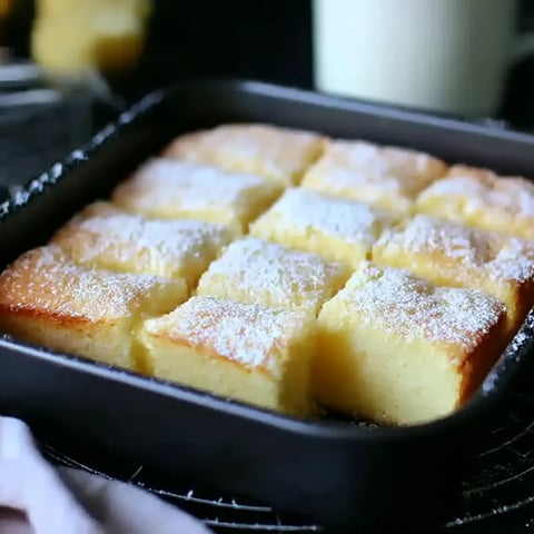 A pan of cake with powdered sugar on top.