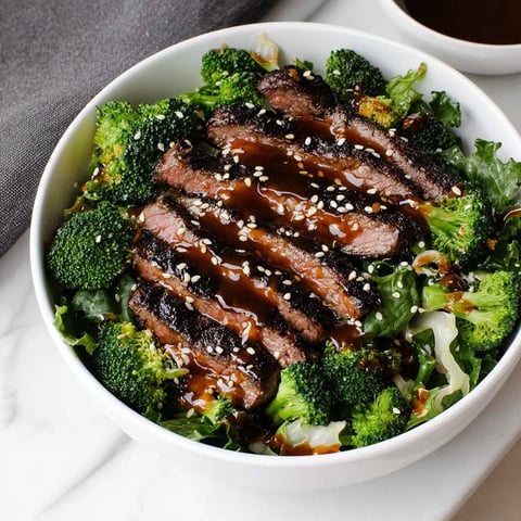 A bowl of meat and broccoli with a brown sauce.