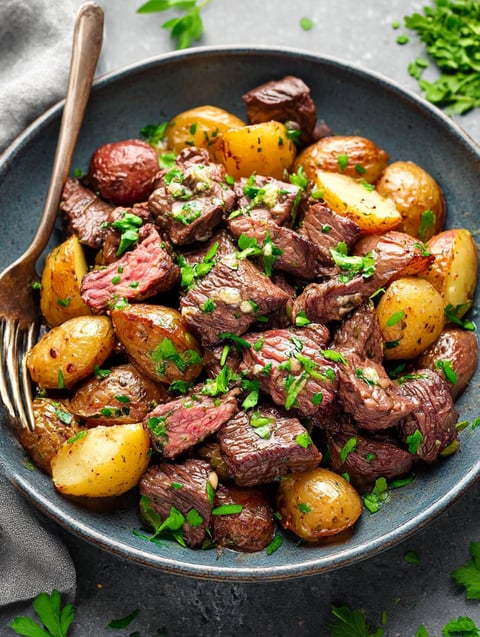 A bowl of meat and potatoes.