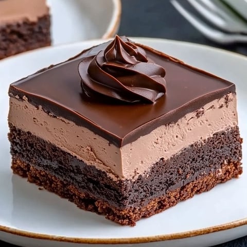 A slice of chocolate cake with a chocolate frosting.